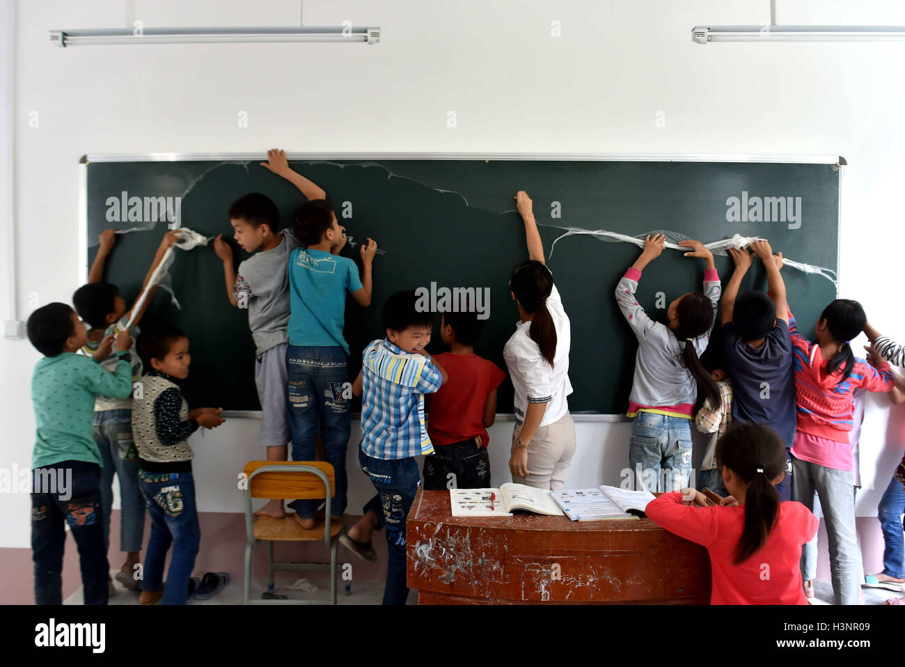 Du an, della Cina di Guangxi Zhuang Regione autonoma. Xx Settembre, 2016. Gli studenti pulire nuova scheda nero nel nuovo edificio costruito a Yudong scuola primaria in Longfu township di Du an Yao contea autonoma, a sud della Cina di Guangxi Zhuang Regione autonoma, Sett. 20, 2016. Piani di Guangxi per migliorare ulteriormente la qualità dell'istruzione residenti in aree depresse durante la Cina del tredicesimo piano quinquennale (2016-2020). © Huang Xiaobang/Xinhua/Alamy Live News Foto Stock