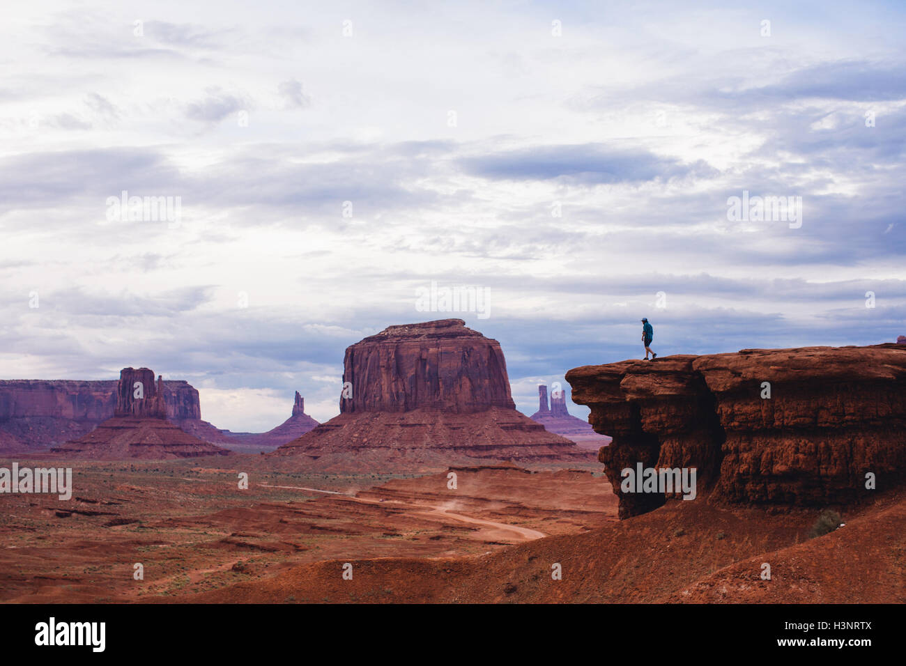 Stagliano uomo sulla cima di pietra arenaria butte, Monument Valley, Arizona, Stati Uniti d'America Foto Stock