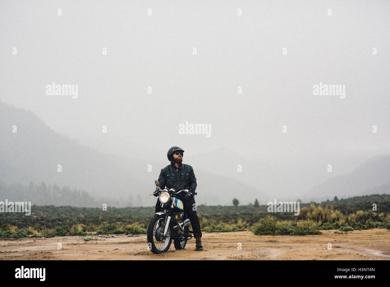 Motociclista che indossa il casco seduto sulla moto che guarda lontano, Kennedy Prati, CALIFORNIA, STATI UNITI D'AMERICA Foto Stock