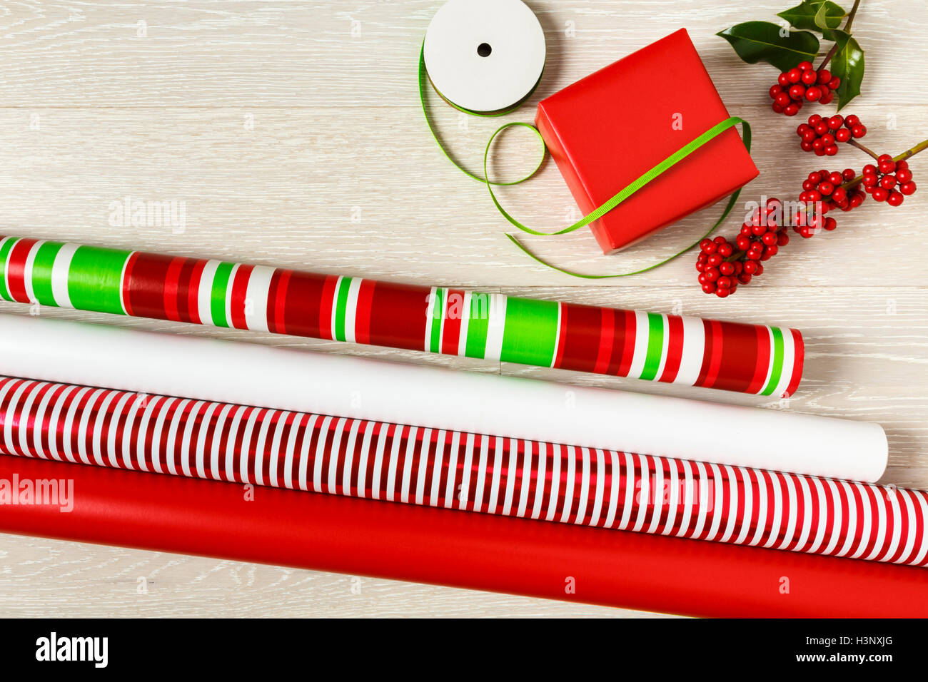 Rosso e verde di Natale la confezione regalo alimenta la carta di avvolgimento, scatola regalo, presente, nastri e botanico naturale holly bacche Foto Stock