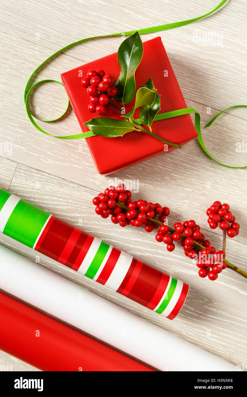 Rosso e verde di Natale la confezione regalo alimenta la carta di avvolgimento, scatola regalo, presente, nastri e botanico naturale holly bacche Foto Stock