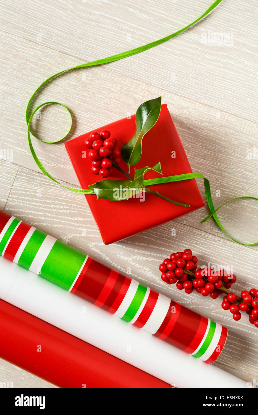 Rosso e verde di Natale la confezione regalo alimenta la carta di avvolgimento, scatola regalo, presente, nastri e botanico naturale holly bacche Foto Stock