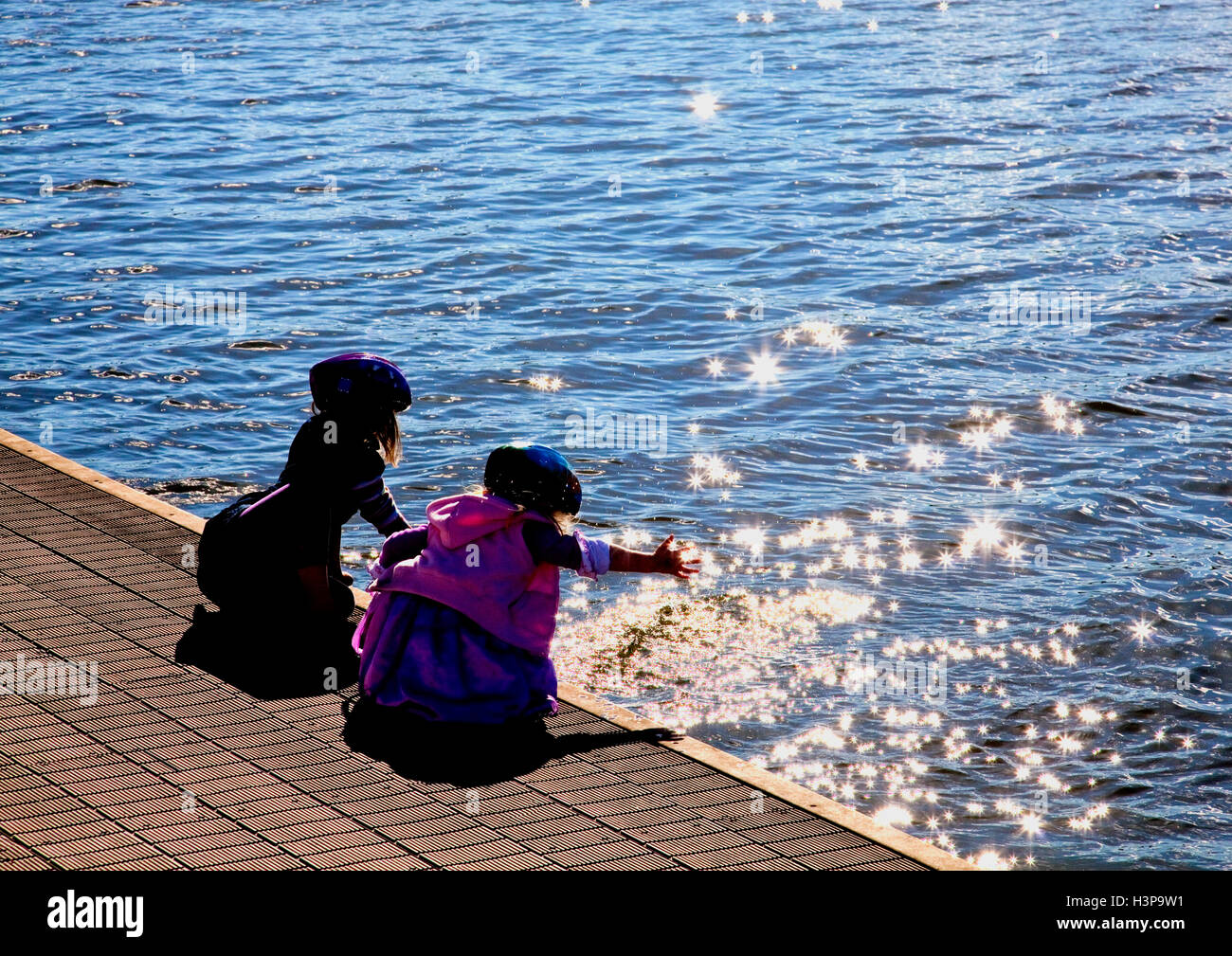 Due bambine raggiungere le stelle in acqua Foto Stock