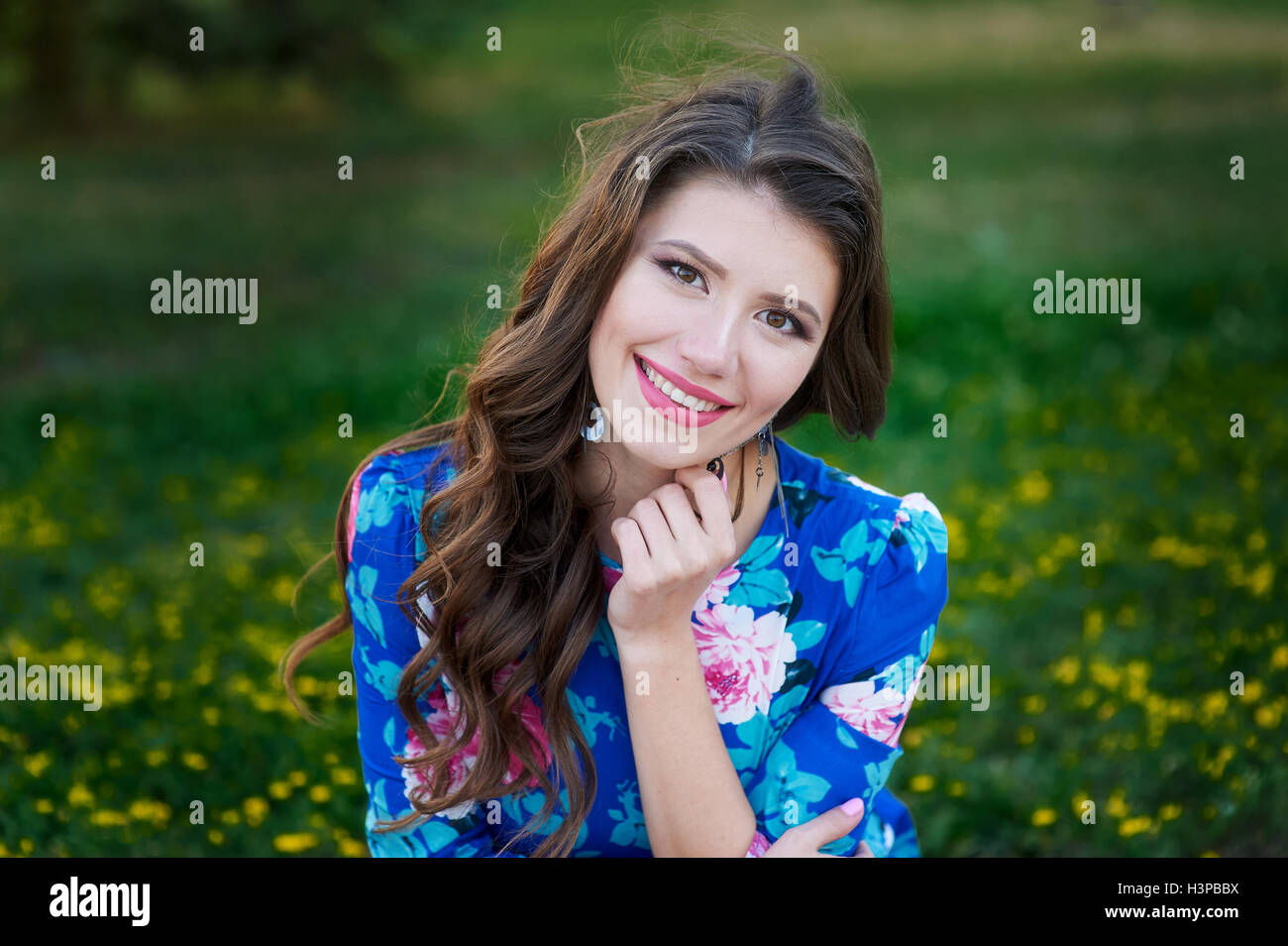 Ritratto di giovane donna riposo nel parco sorridente sull'erba Foto Stock