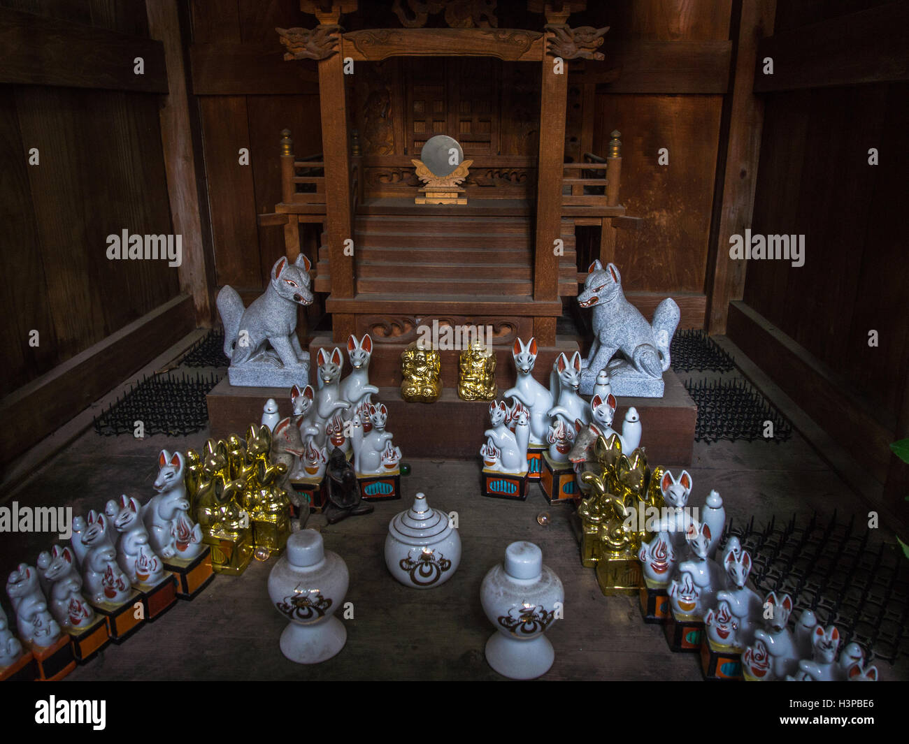 Lo Shintoismo santuario stradale offerte di inari tofu e kitsume fox guardian figure, un sacro specchio, Kawagoe Saitama, Giappone. Foto Stock