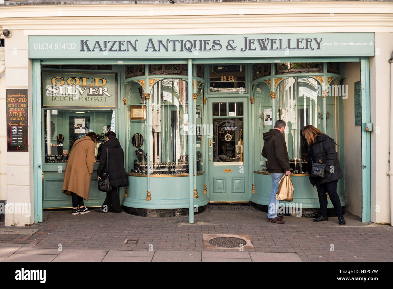 La gente cerca attraverso la finestra del Kaizen Antiquariato & gioielleria, Rochester, Kent, Regno Unito Foto Stock
