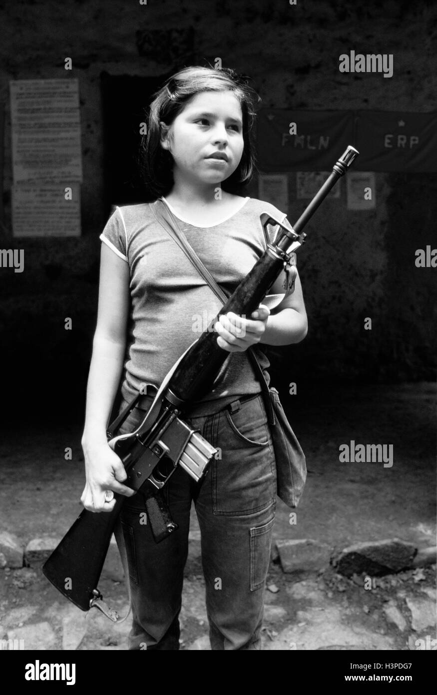 CHALATENANGO, EL SALVADOR, FEB 1984: - all'interno del FPL Guerrilla zone di controllo - Una giovane ragazza tiene un M16 fucile. Foto Stock