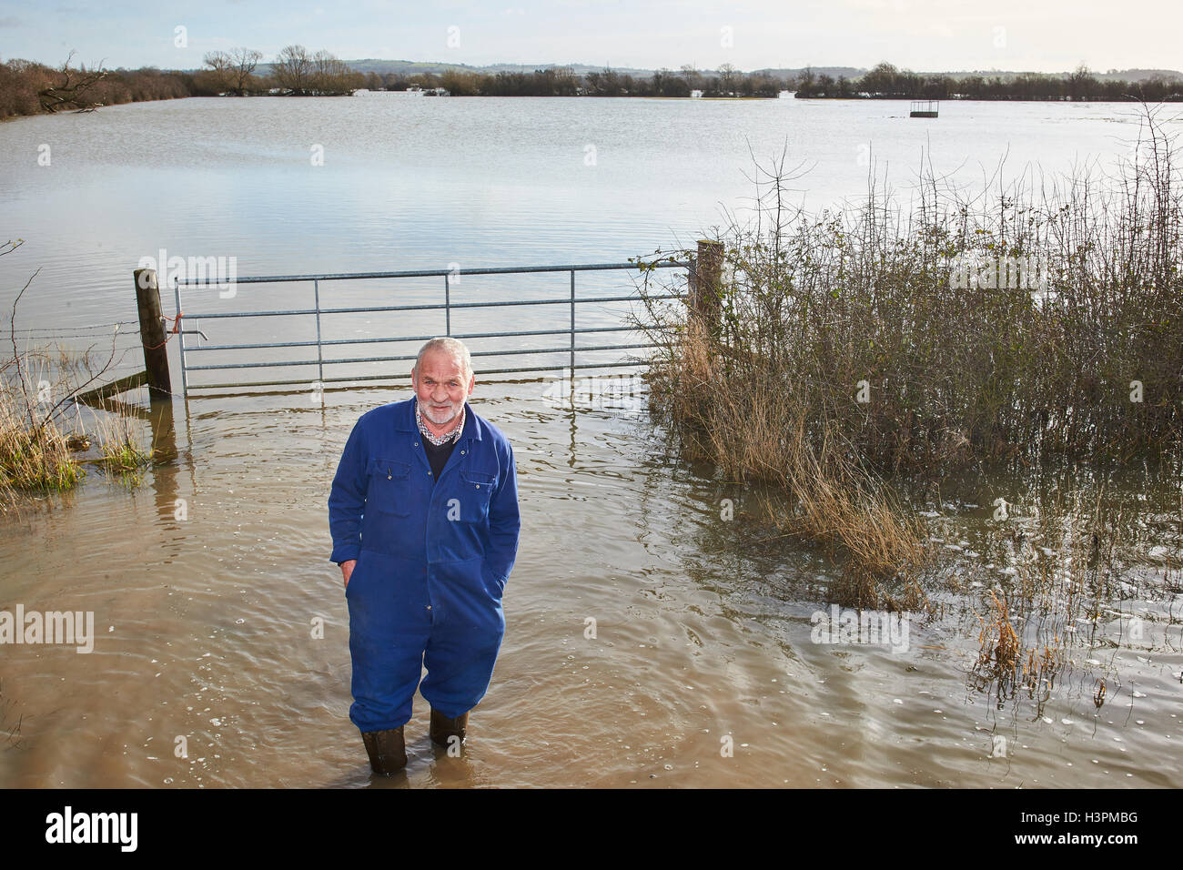 Un agricoltore guarda al profondo acqua di inondazione per la sua azienda di campi durante il mese di febbraio 2014 Inondazioni in Oxfordshire Foto Stock