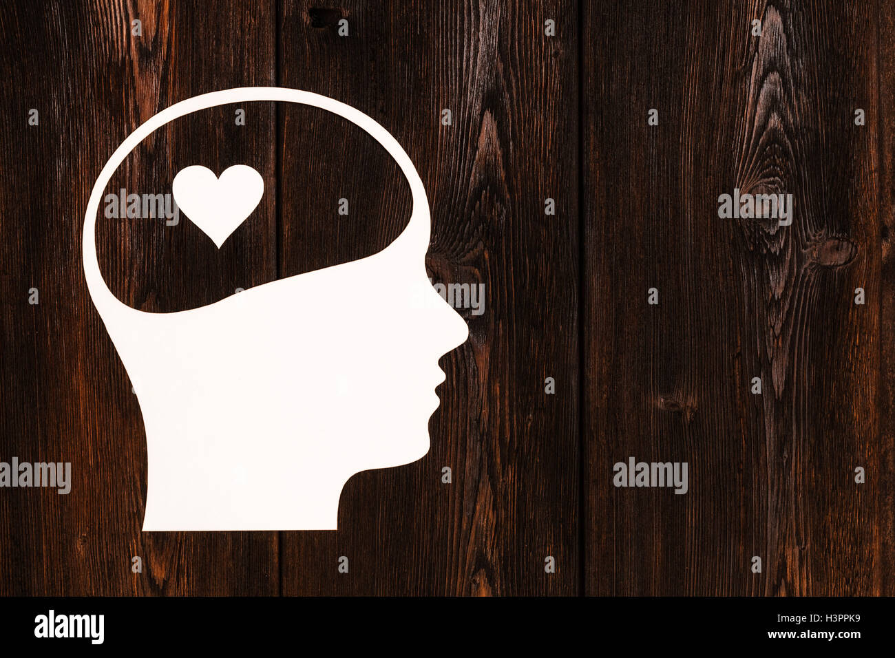 Testa di carta con cuore all'interno. Abstract immagine concettuale, copyspace Foto Stock