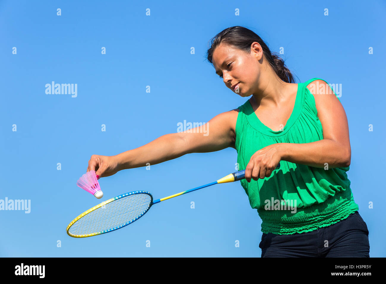 Donna olandese servire con badminton racchetta e la navetta contro il cielo blu Foto Stock