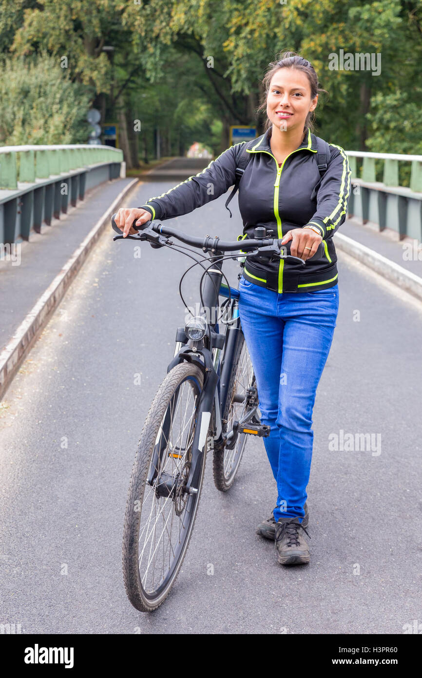 Unione donna in piedi con ATB mountainbike sul ponte Foto Stock