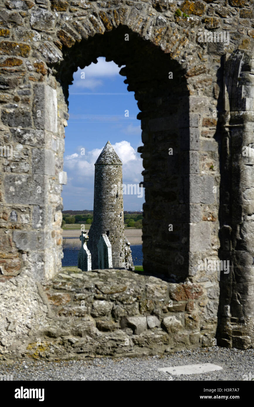 Stone round tower alto cross attraversa il monastero di Clonmacnoise insediamento monastico Offaly RM Irlanda Foto Stock