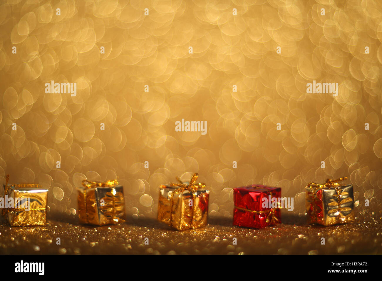 Decorativi piccoli regali di Natale sul golden lucido sfondo bokeh di fondo Foto Stock