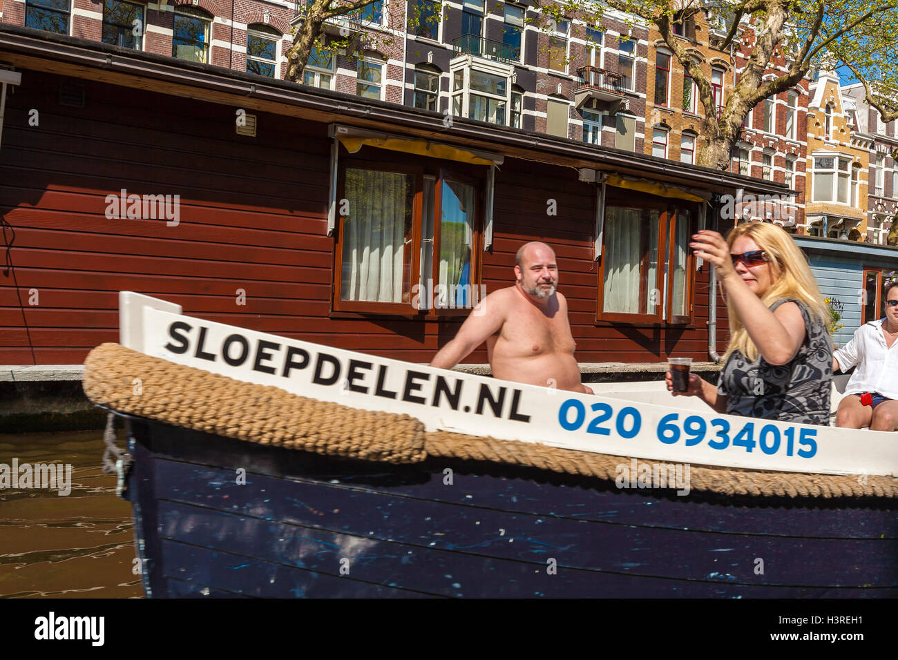 AMSTERDAM, Paesi Bassi - 3 Aprile 2008: la famosa casa sull'acqua e la gente del posto barca sui canali Foto Stock