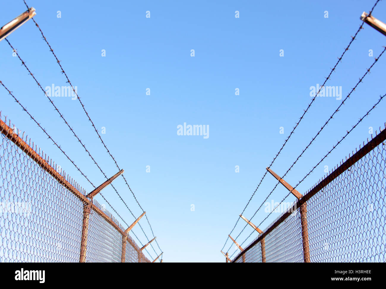 Il passaggio pedonale tra siti industriali protetti da alta recinzione cablata (Seattle, Washington). Foto Stock