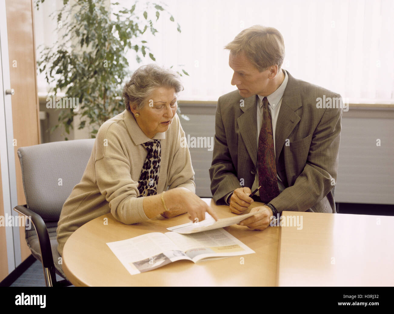 Senior, Cassiere, consultazione, istituzione finanziaria, istituto di credito, uomo donna, lavoratore di ufficio, conversazione, consultazione, consultare, informazioni, informare, assicurazione, agente di assicurazione, sedersi all'interno Foto Stock