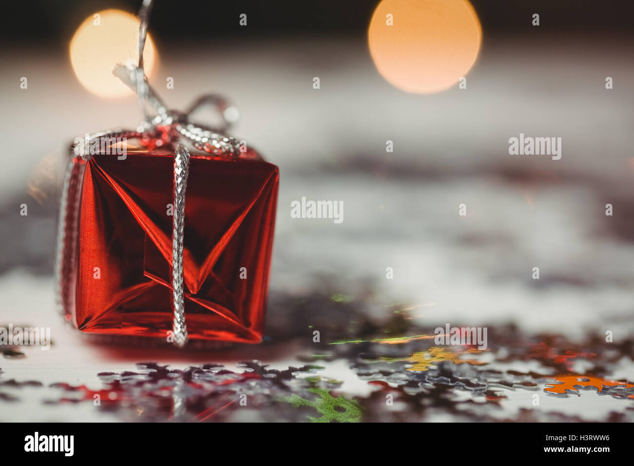 Piccolo avvolto confezione regalo e il simbolo del fiocco di neve sparsi sul tavolo di legno Foto Stock