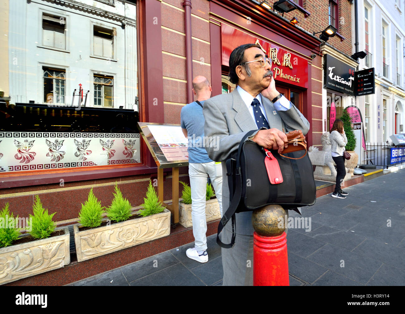 Londra, Inghilterra, Regno Unito. Ben vestito uomo a Chinatown Foto Stock