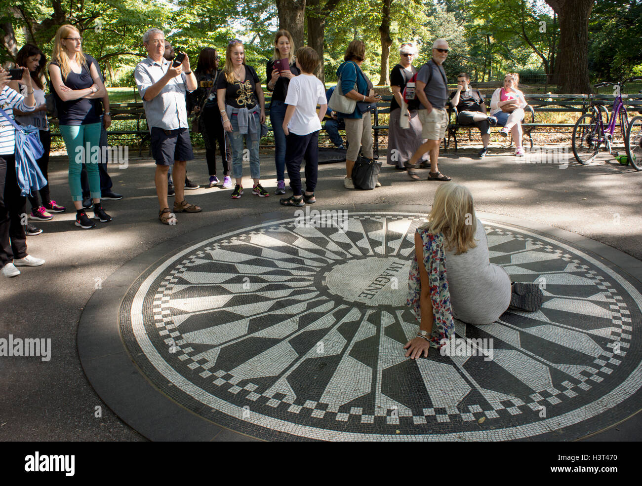 I turisti in posa sul mosaico immaginare la memoria di John Lennon in Strawberry Fields. Central Park, Manhattan, New York. Foto Stock