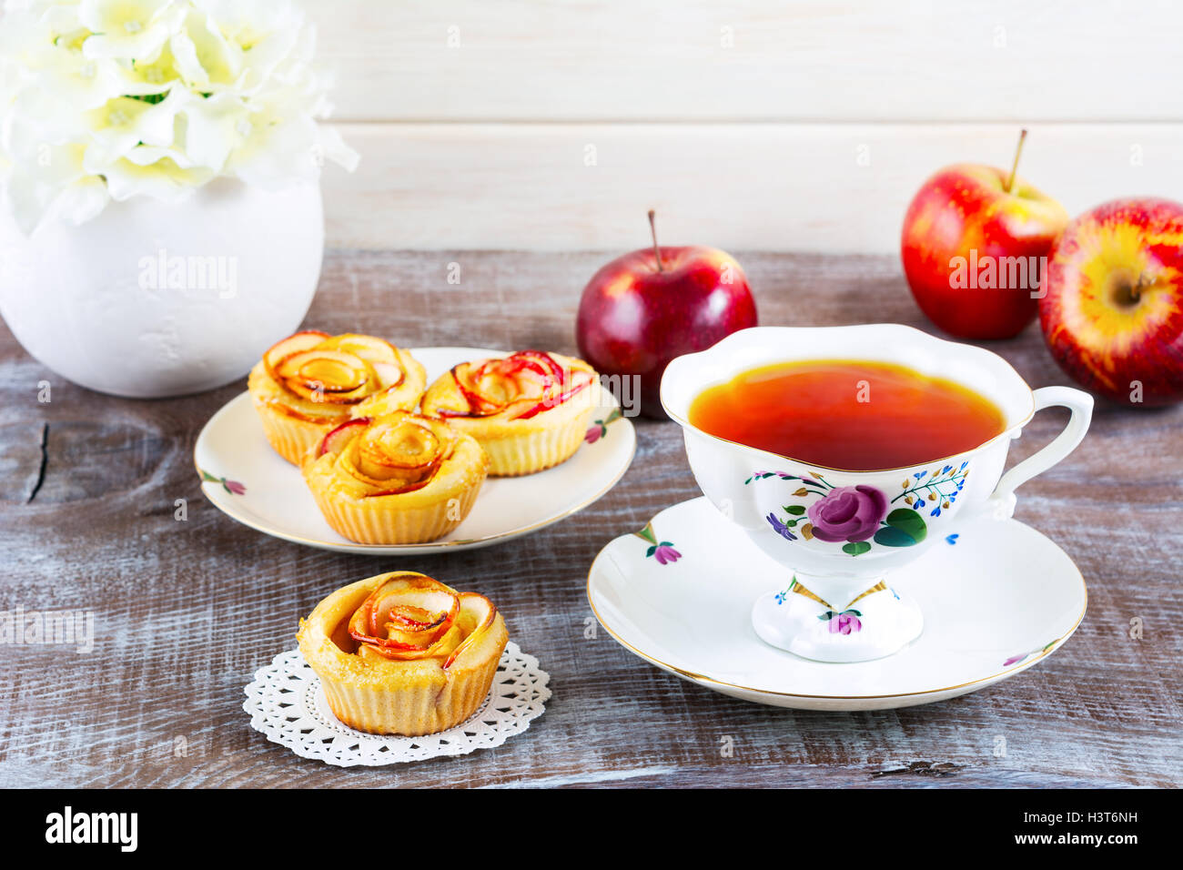 Tazza di tè e caffè e muffin con rosa a forma di fette di apple. Dolce dessert apple pie. In casa apple pasticceria Rosa. Colazione tè con sw Foto Stock