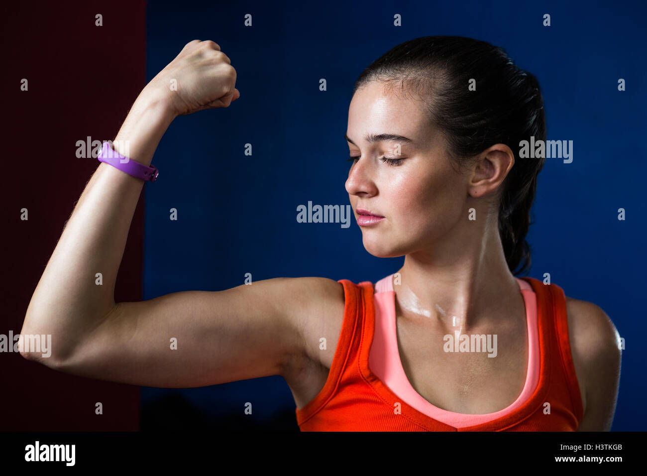 Close-up di donna flettendo i muscoli in palestra Foto Stock