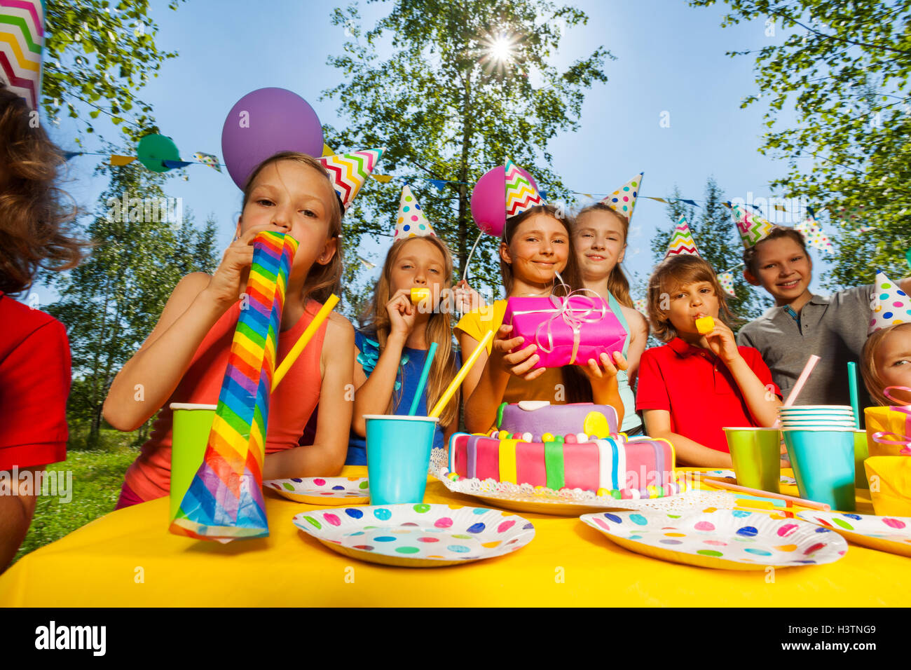 Contenti i bambini soffiando fischietti in outdoor B-giorni di festa Foto Stock