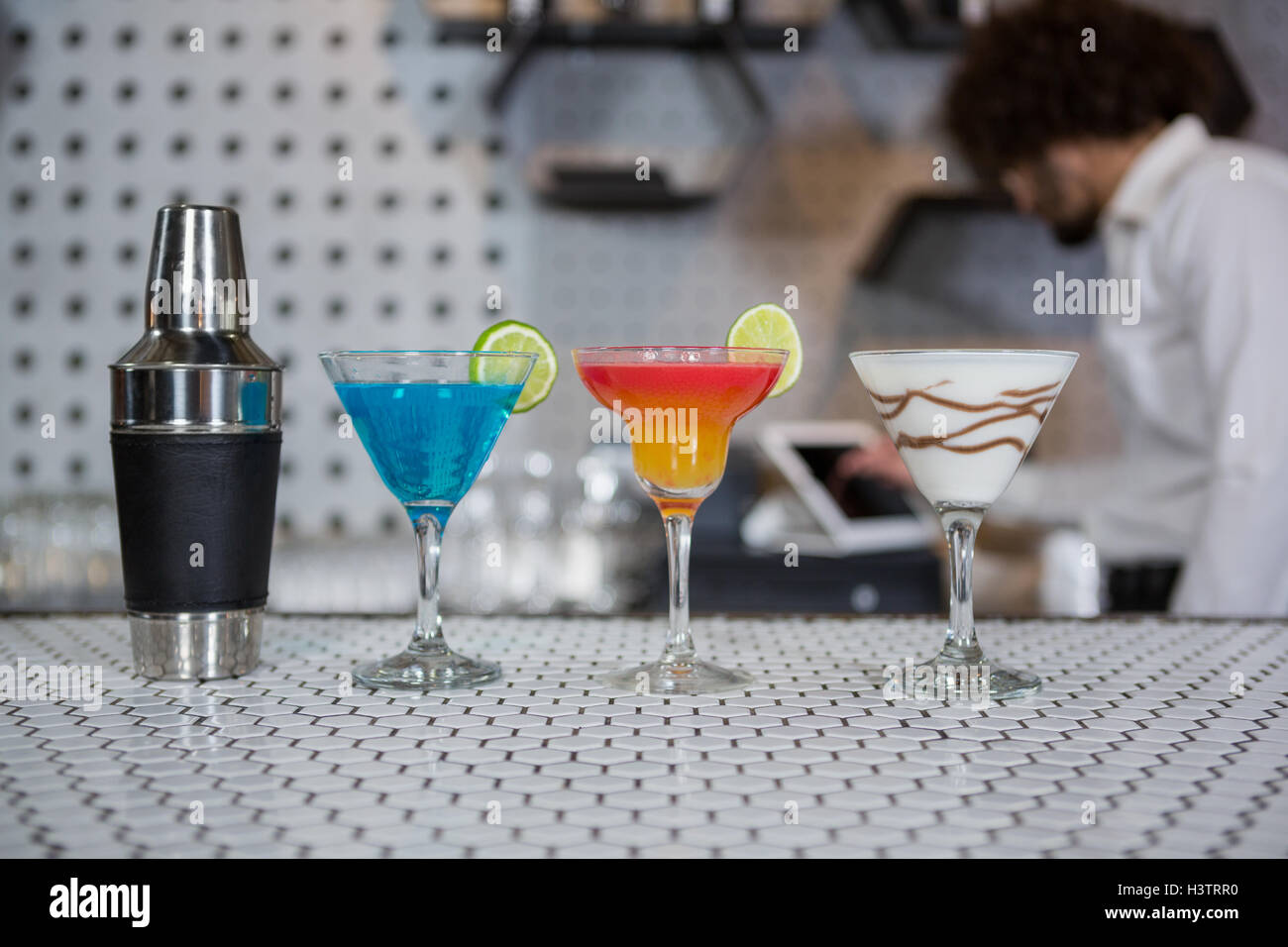 Vari cocktail bevande e cocktail shaker su un banco di bar Foto Stock