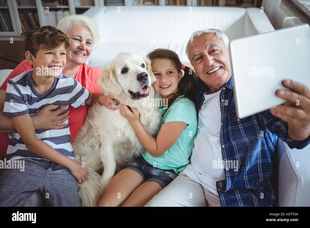 Nonni e nipoti prendendo un selfie con tavoletta digitale Foto Stock