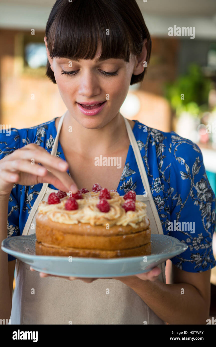 Cameriera di toccare la ciliegia sulla torta top Foto Stock
