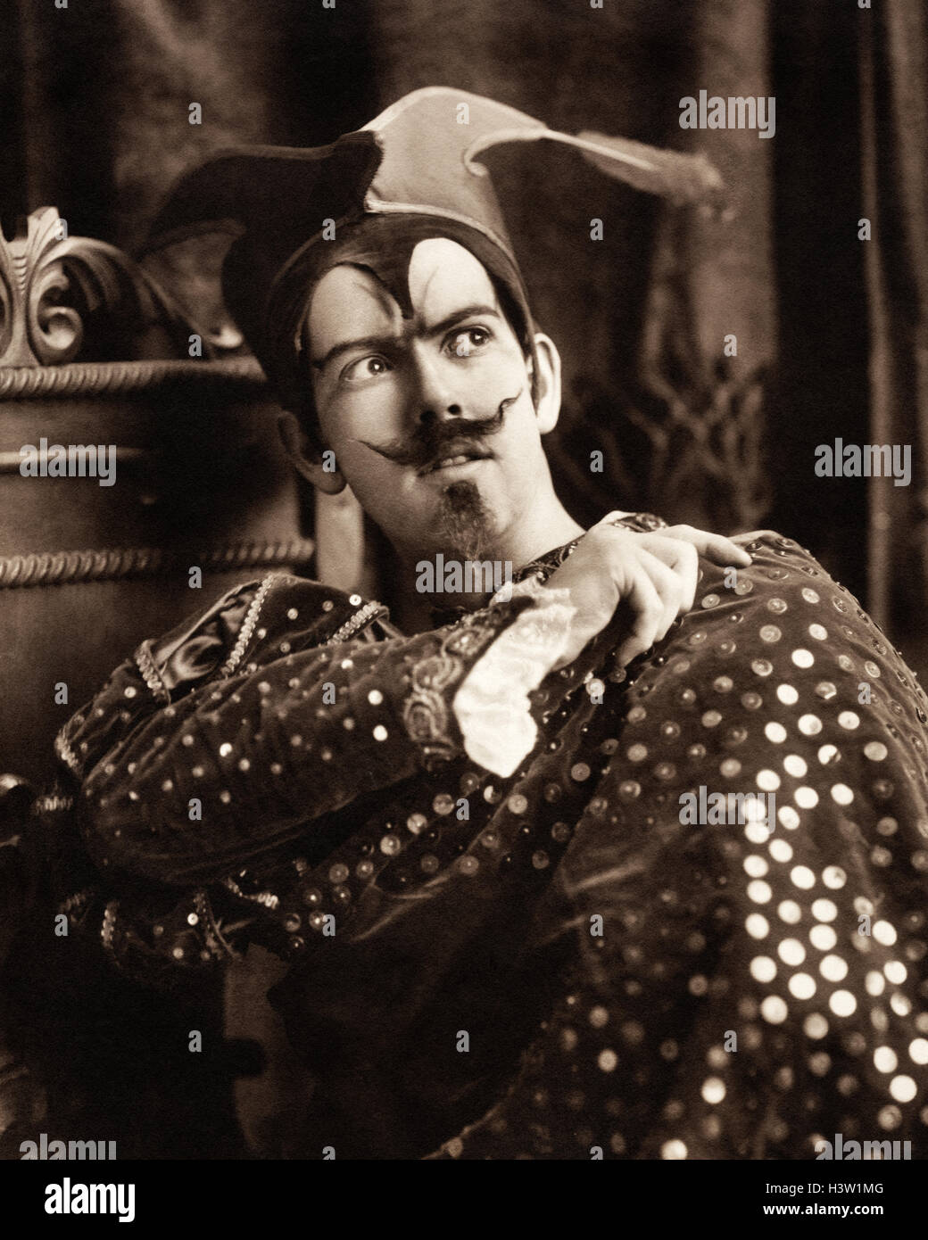 1900s uomo in costume teatrale guardando al lato mantello SEQUINED BAFFI PIZZETTO SATANICO CARATTERE DIAVOLO MEPHISTOPHELES Foto Stock
