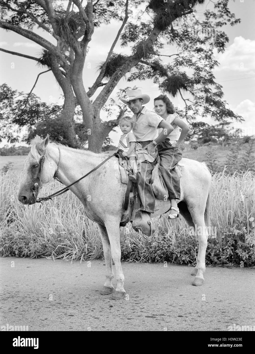 Anni Cinquanta uomo donna bambino tutti seduti su un cavallo guardando la fotocamera vicino alla città di SIBANICU NELLA PROVINCIA DI CAMAGUEY CUBA Foto Stock