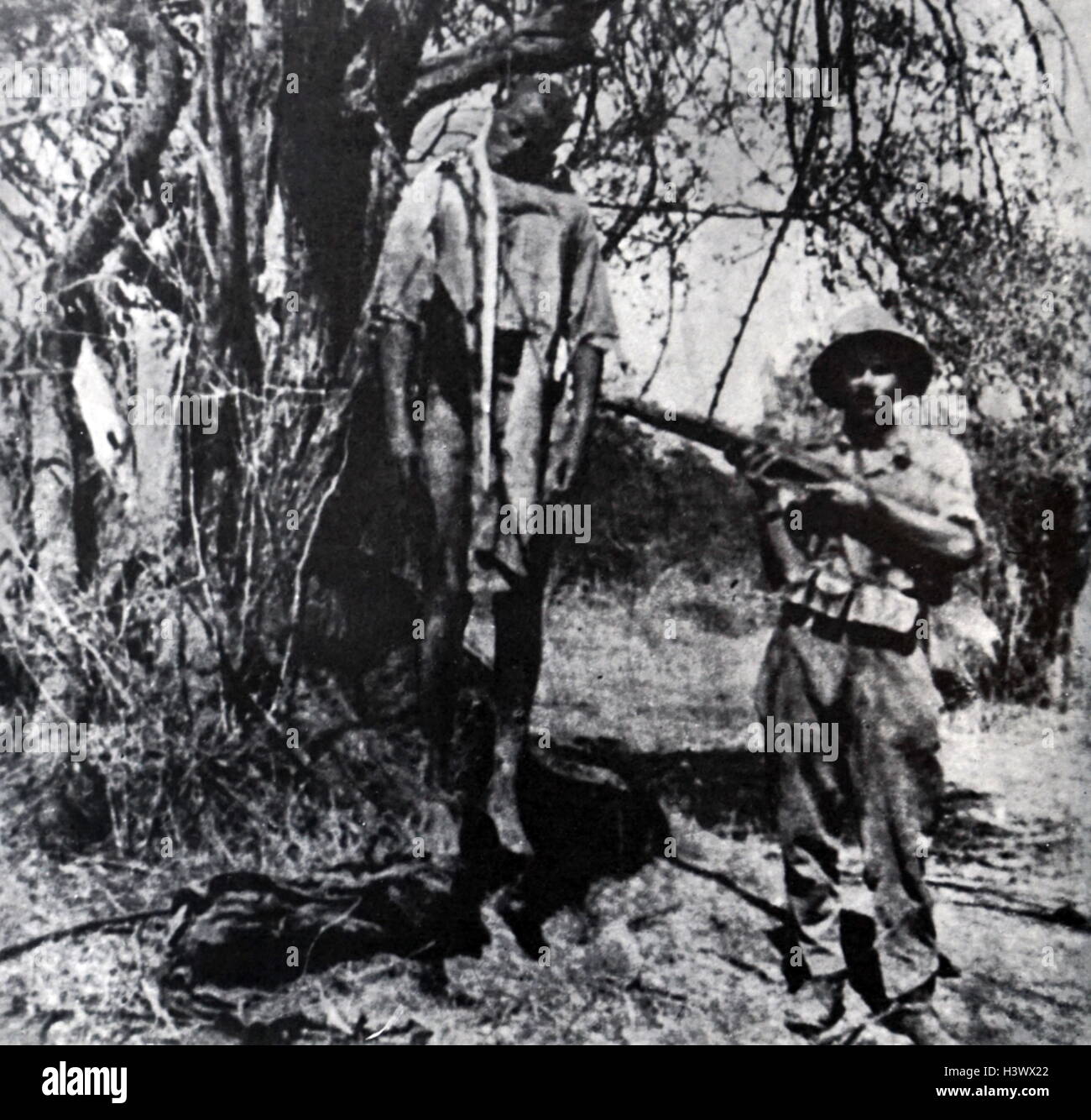 Fotografia di un soldato italiano accanto a un cadavere appeso durante la caduta di Abissinia. In data xx secolo Foto Stock