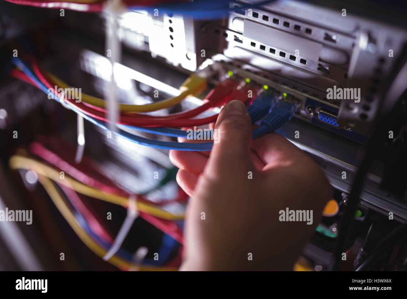 Close-Up del tecnico collegando il cavo patch in un rack server Foto Stock