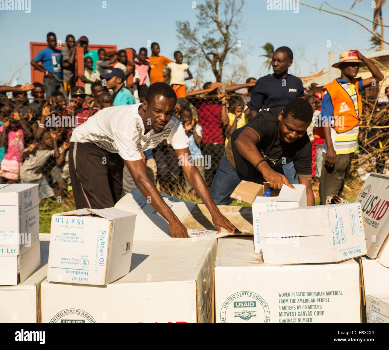 Gli haitiani rush per aiutare a scaricare viveri consegnati dai marines degli Stati Uniti per aiutare le persone colpite dall'uragano Matthew Ottobre 11, 2016 a Dame Marie, Haiti. Uragano Matthew ha colpito Haiti con venti oltre 140 mph uccidendo 500 persone e causando danni diffusi. Foto Stock