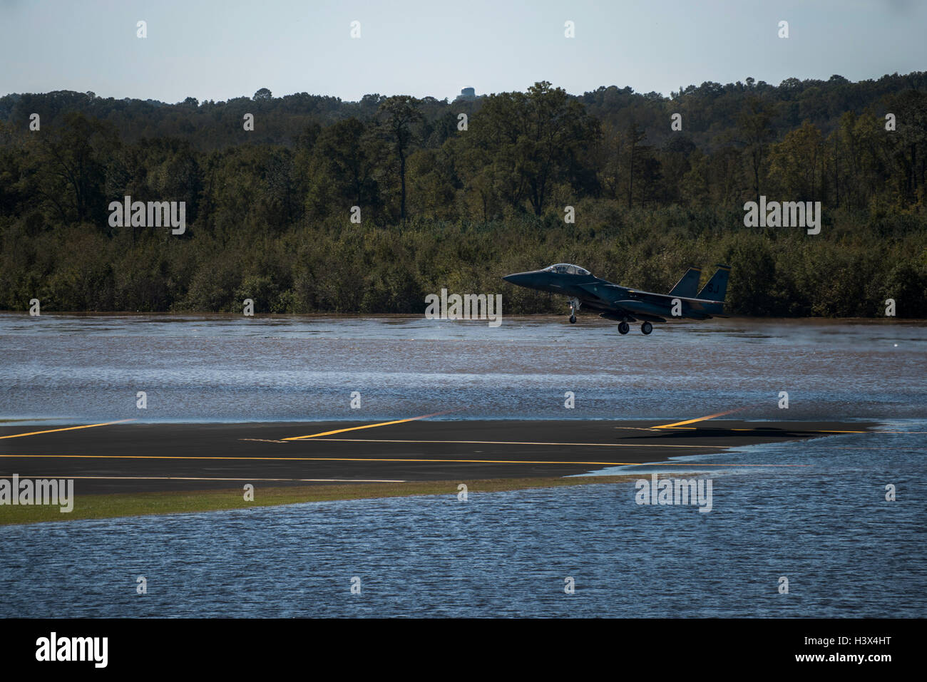 Un U.S Air Force F-15E Strike Eagle fighter aircraft atterra sul parzialmente sommerso pista inondata dall uragano Matthew presso Seymour Johnson Air Force Base di ottobre 11, 2016 in Goldsboro, North Carolina. Il Fighter Wing è di ritorno dopo il riposizionamento per evitare l'uragano. Foto Stock