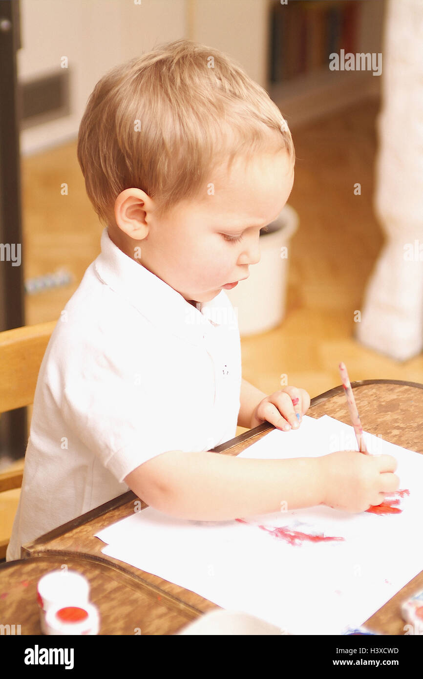 Bambino, ragazzo, acquerelli, vernice, concentrazione, 3 anni, boy, infanzia, illuminante, naturalezza, attività, segno, colori, pennelli, creatività, gioco, all'interno Foto Stock