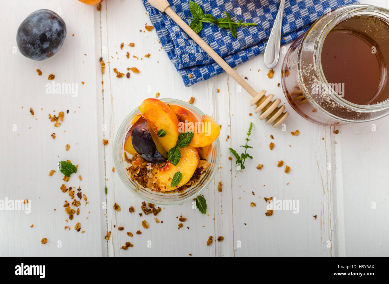 Lo yogurt greco con frutta fresca e granola con miele, succo di frutta fresco Foto Stock