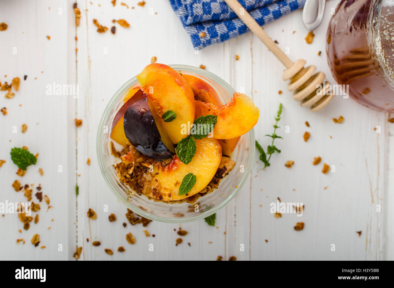 Lo yogurt greco con frutta fresca e granola con miele, succo di frutta fresco Foto Stock