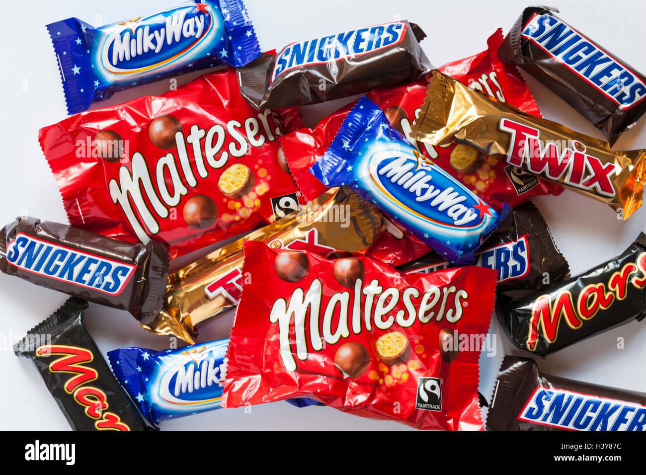 La dimensione del divertimento preferiti familiari, selezione di Marte, Snickers, Twix, la Via Lattea e cioccolato Maltesers impostato su sfondo bianco - guardando verso il basso a partire da sopra Foto Stock