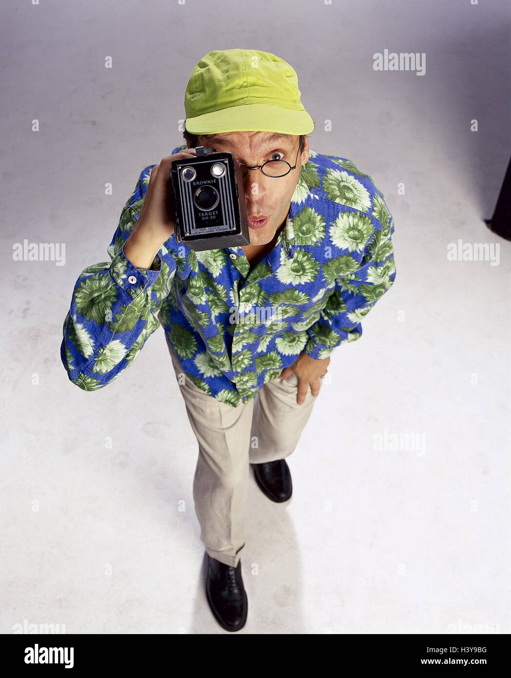 L'uomo, fiore camicia, segno cap, la telecamera video, film, giocare per il viso, uomini, fotocamera, fotografia, studio, vacanza, vacanziere, turistico, scoperta, interesse, curiosità, sorpresa, stupito Foto Stock