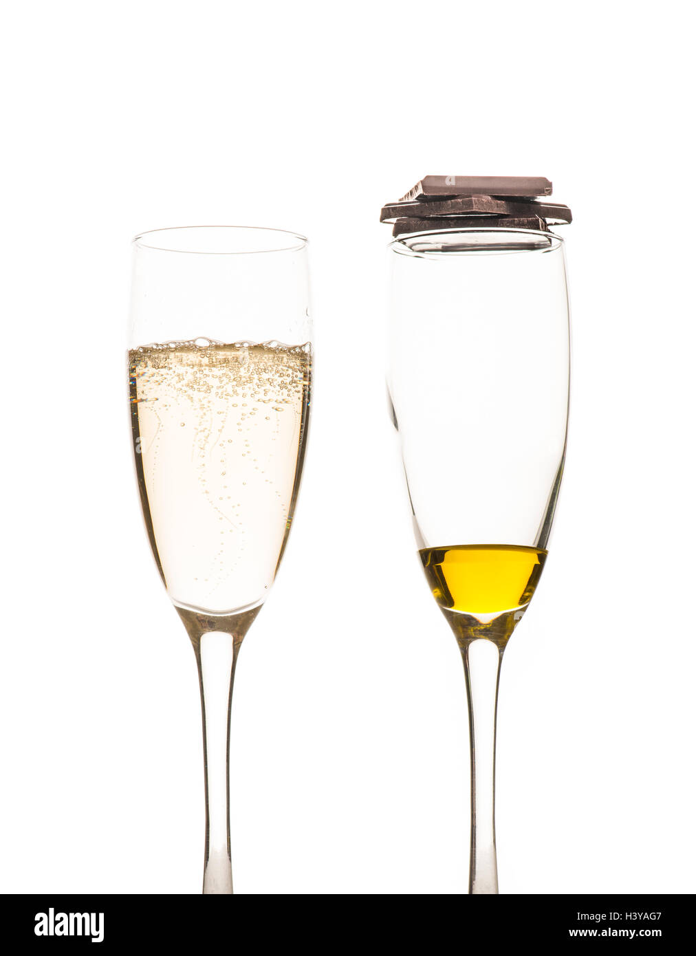 Vino bianco frizzante in vetro di champagne. Olio di oliva e il cioccolato fondente. Foto Stock