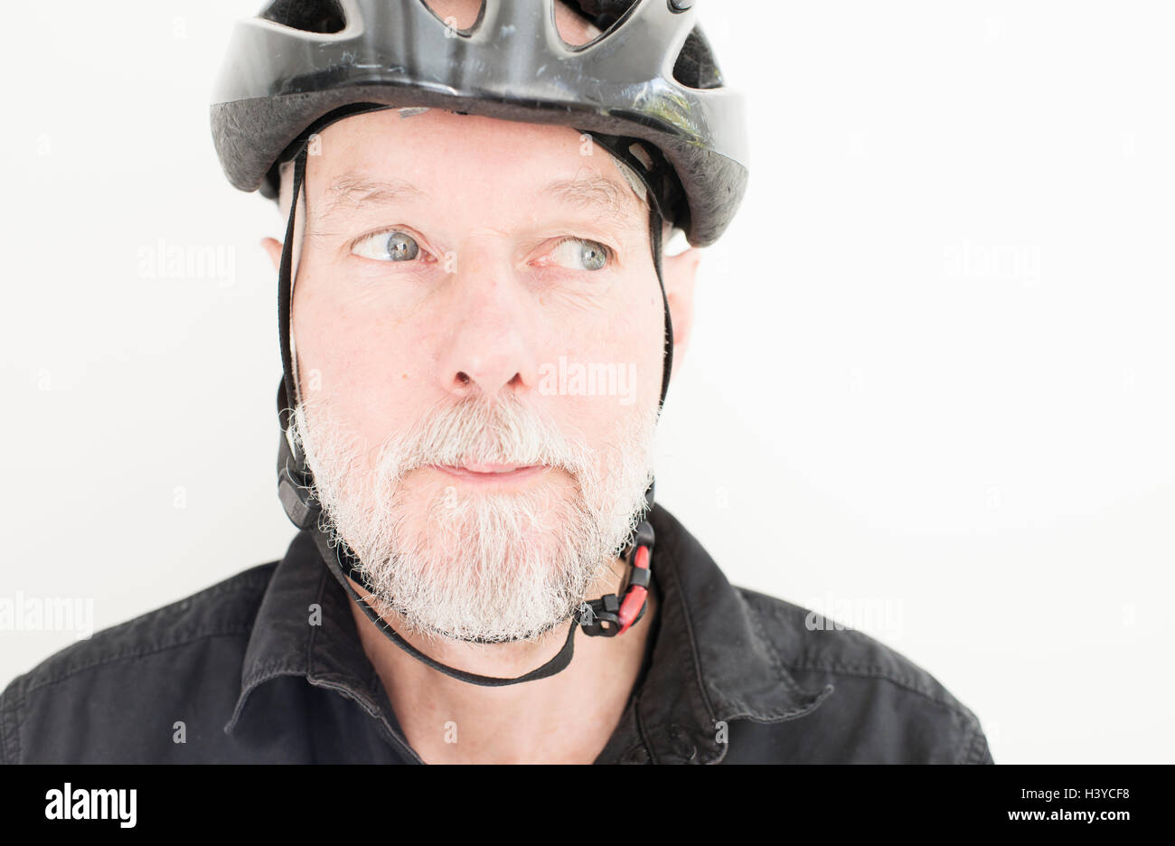 Chiusura del vecchio uomo che indossa un casco per bicicletta. Ritratto di persone anziane che vivono una vita attiva con uno stile di vita sano. Foto Stock
