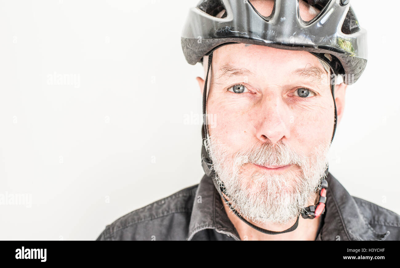 Chiusura del vecchio uomo che indossa un casco per bicicletta. Ritratto di persone anziane che vivono una vita attiva con uno stile di vita sano. Foto Stock