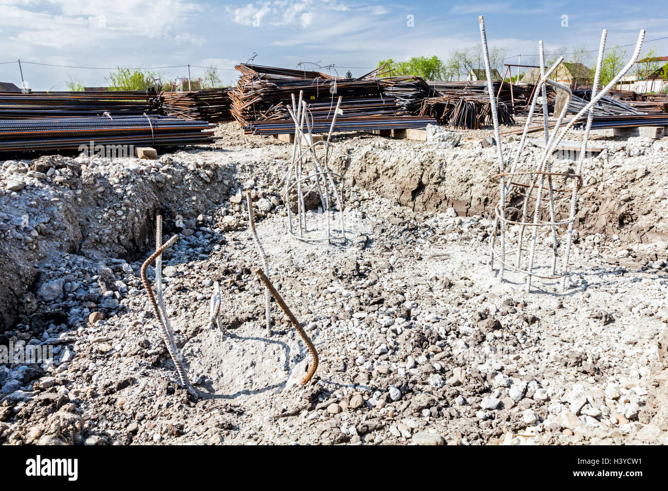 Scheletro di acciaio di rinforzo, armatura, bar al cantiere è sepolto nella terra depositata con il cemento. Foto Stock