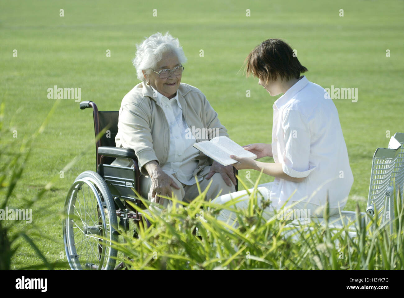 Senior, invalida la sedia a rotelle, vecchio infermiere, prenota, leggere, vecchia casa di riposo, la vecchia casa di riposo, Senior Citizen's home, giardino, parco, donna vecchia, vecchia persona titolare di pensione o di rendita, il titolare di pensione o di rendita, felicemente, sorridere leggere la gioia, infermiere, intrattenimento, cura, aiuto, guida, preoccupazione, assegno, Cura geriatrica, personale infermieristico, senior citizen care, sociale occupazione, singolo, infermieristica-indigenti, che hanno bisogno di cure, walking-ostacolato, impedimento a piedi, impedimento ostacola, solitudine Foto Stock