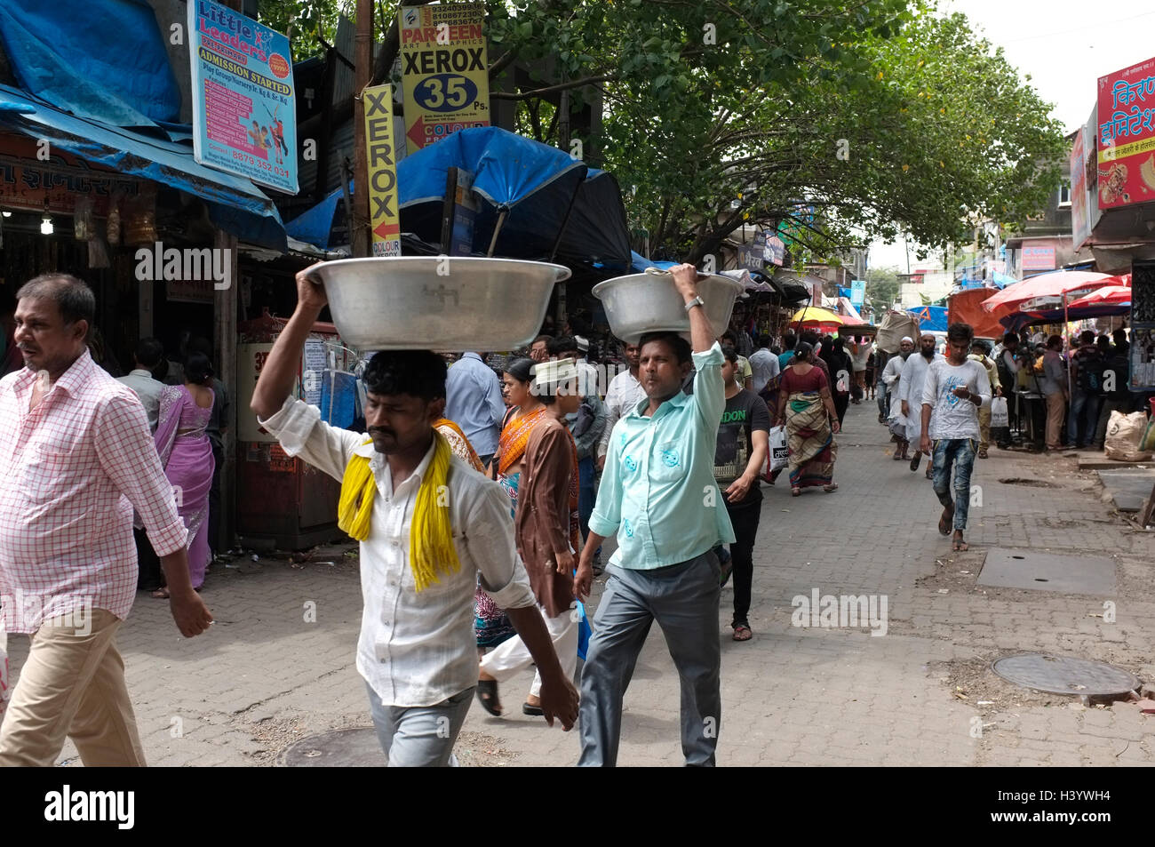 I giovani portano a bocce sulle loro teste attraverso kurla distretto. Scene di strada di Mumbai, India Foto Stock