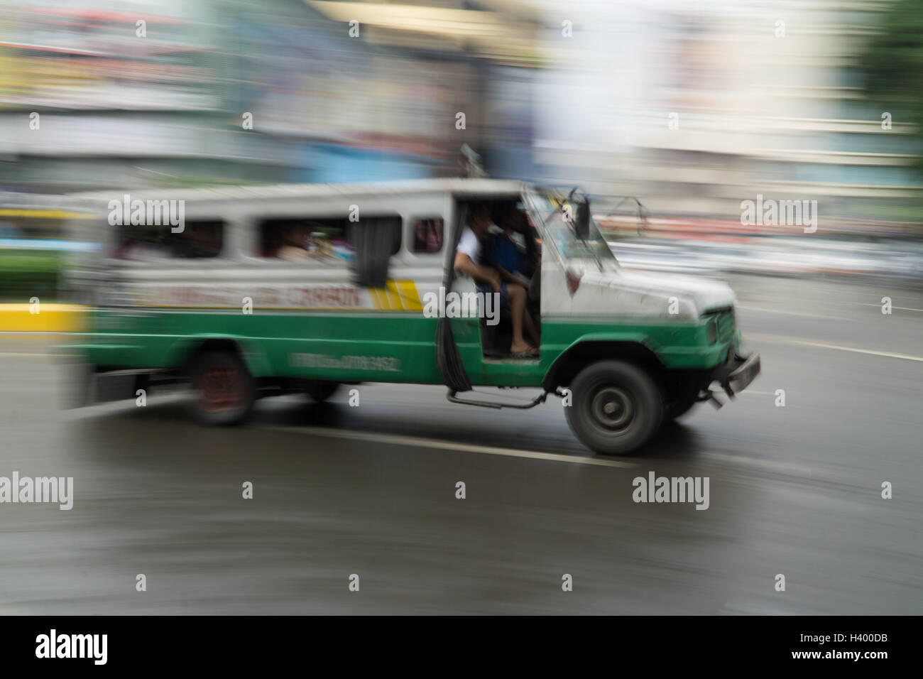 Bassa velocità dell'otturatore della fotocamera esagerando il movimento di un multicab di veicoli per il trasporto pubblico a Cebu City, nelle Filippine. Foto Stock