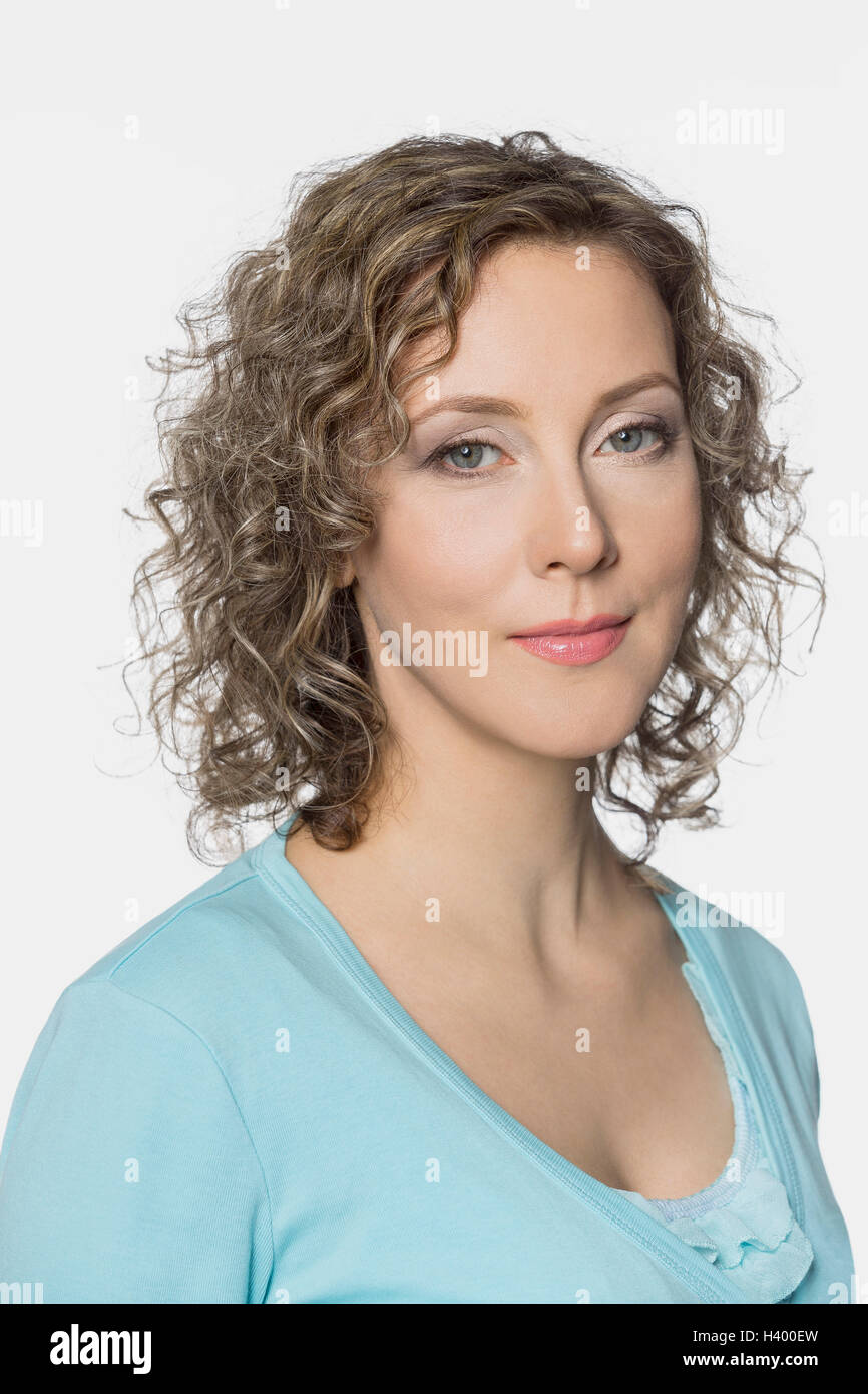 Ritratto di sorridente bella donna con capelli ricci contro uno sfondo bianco Foto Stock