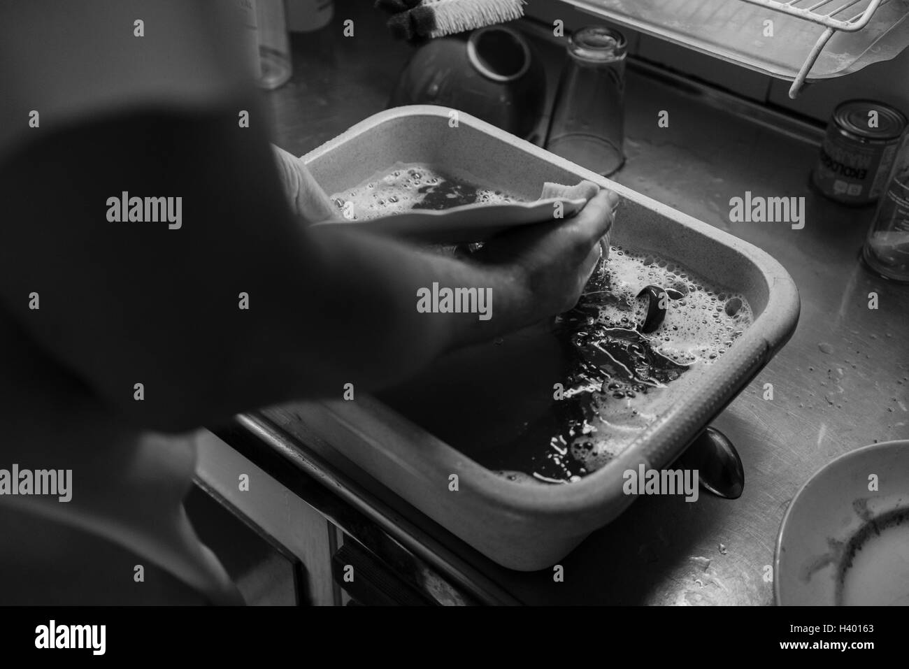 Uomo utensili di lavaggio nel trogolo in cucina Foto Stock