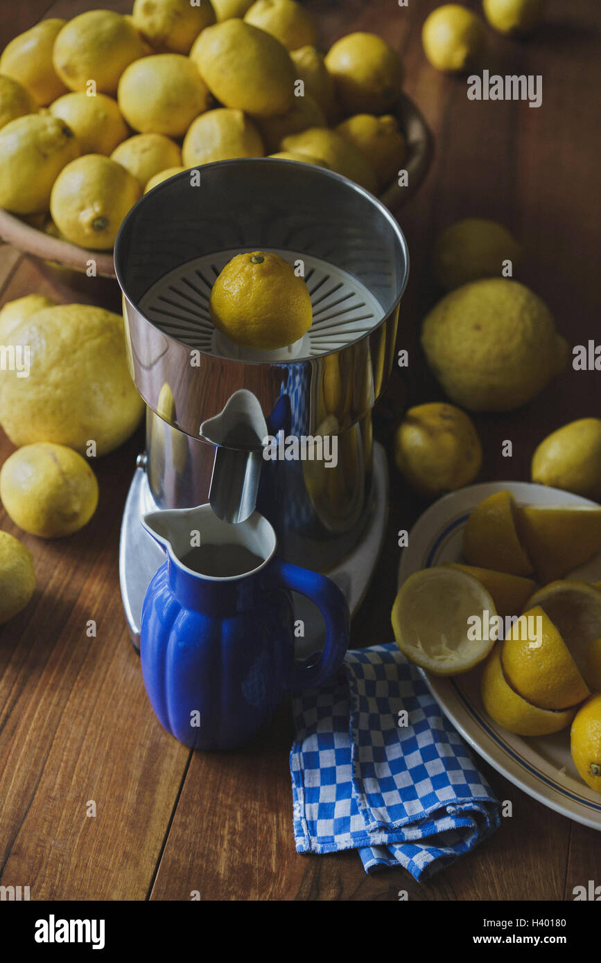 Brocca blu e spremiagrumi elettrico da limoni sul tavolo di legno Foto Stock